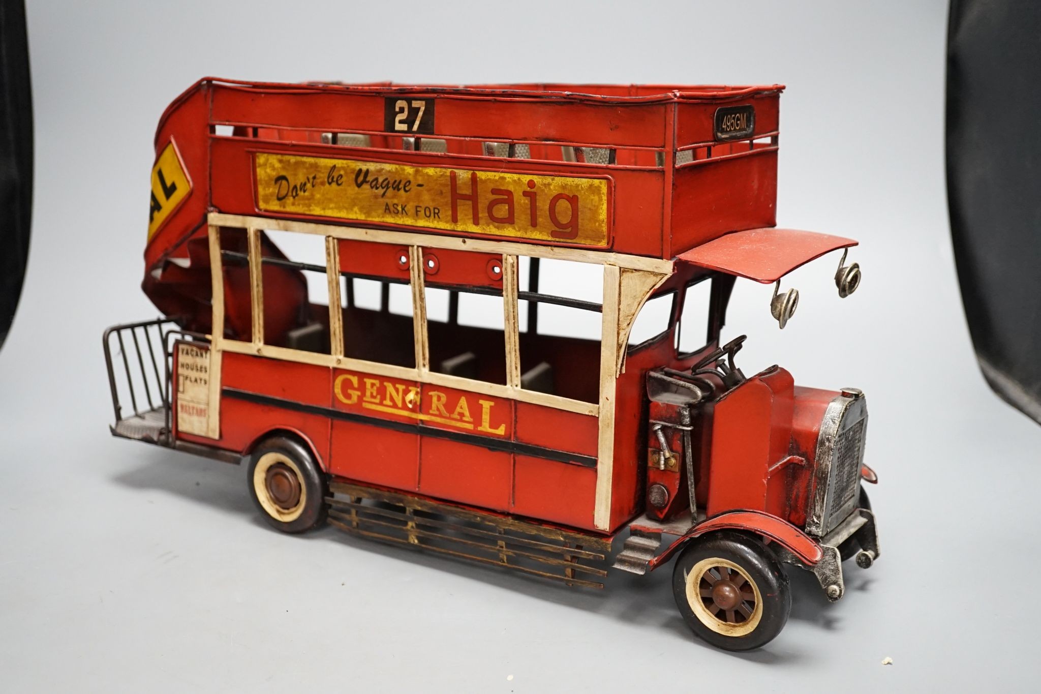 A reproduction tinplate double decker topless bus, the side reading ‘Don’t be vague - ask for Haig’, 42cm long